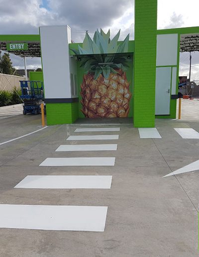 A Boost Juice drive thru store showing the directional arrows painted on the ground and pedestrian crossings.