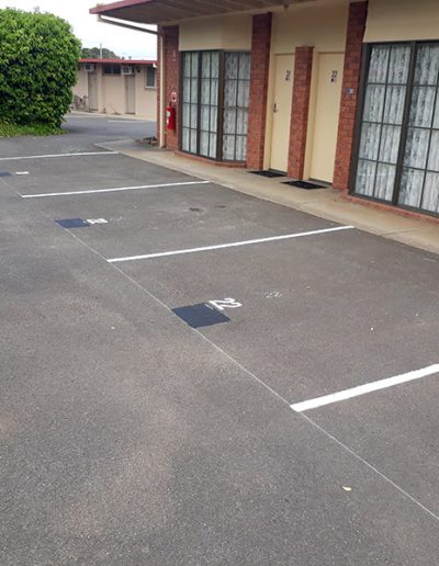Numbered carparks outside motel rooms.